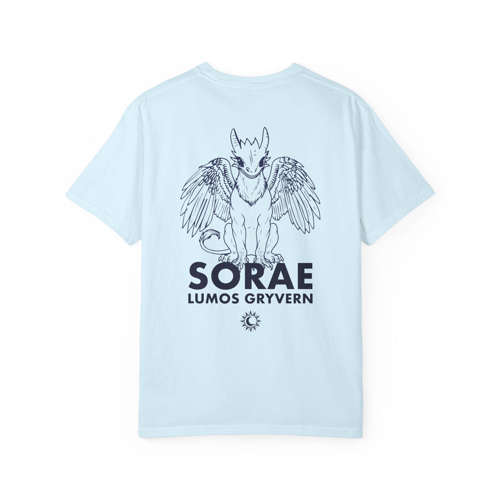 The thtgrlreads Kindred's Curse Saga Comfort Colors graphic tee features a light blue 100% ring-spun cotton base with a black line art print of a winged gryvern and bold text, officially licensed by Penn Cole and available through Printify in the Tees collection.